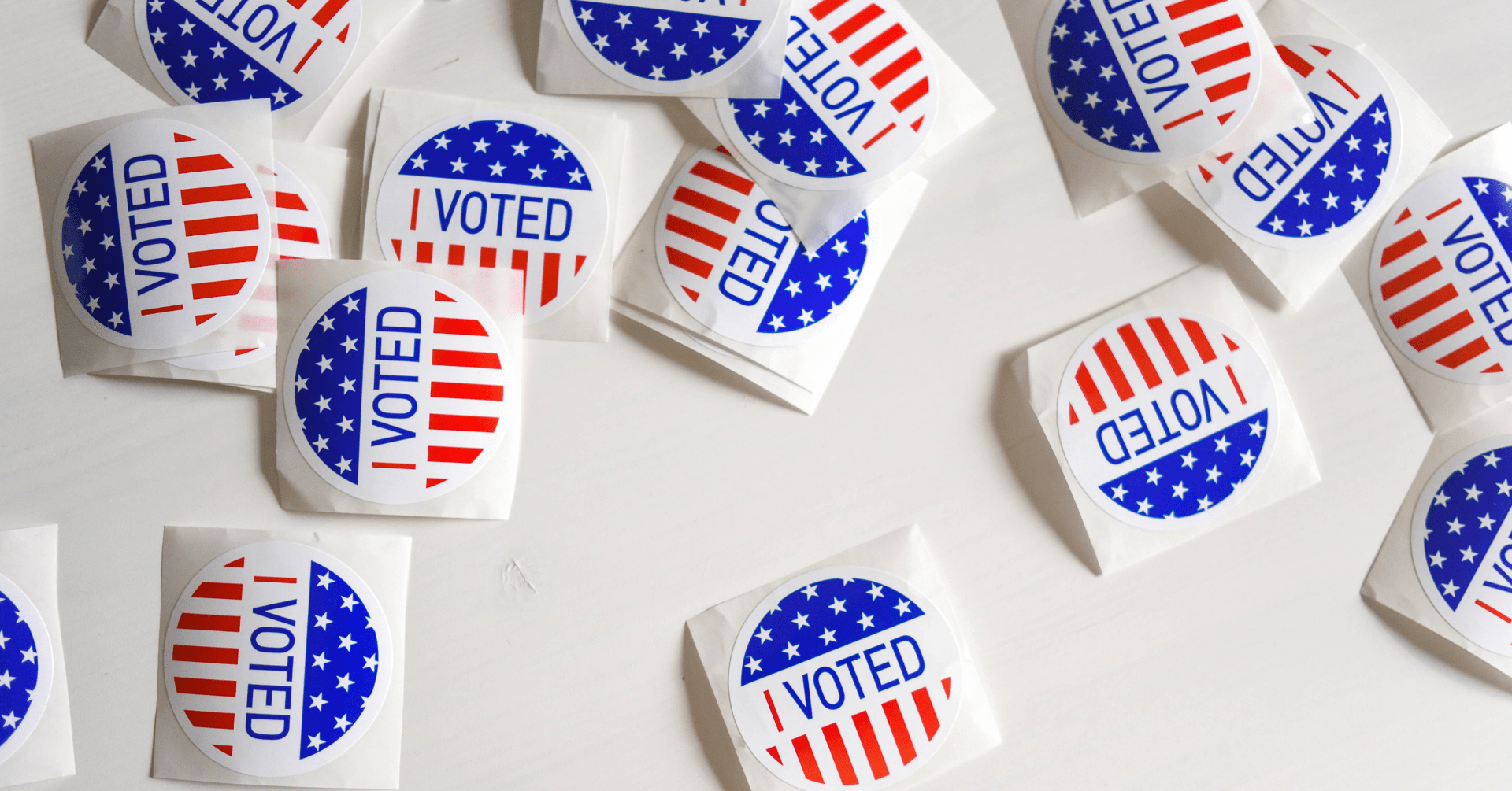 A spread of stickers on a white table that say "I Voted"