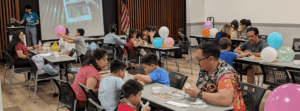 a room full of families sitting at tables playing lotería
